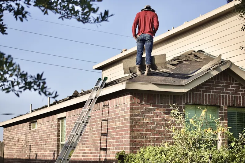Professional roofer working on a residential roof in Espanola